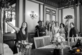   At Château Le Haget in Gers, a bridesmaid gathers with the bride, maid of honor, and witnesses, snapping a cheerful group photo with her phone to remember the occasion.